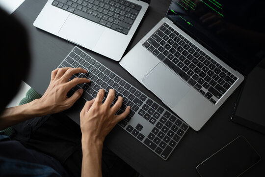 Asian man software engineer Working on Computer at office desk for writing program code IT Software Engineer finding errors tech support devops creating digital