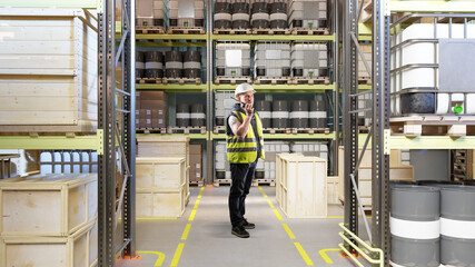 Warehouse operations supervisor coordinates stock handling via radio, managing inventory flow, crate movement, and storage of industrial containers on organized shelving.