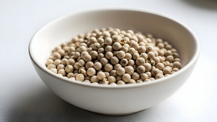 White peppercorns in white bowl macro shot aromatic ingredient