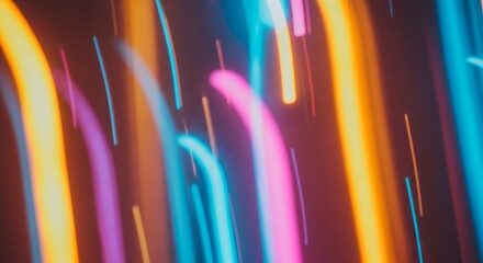 Abstract motion blur of vibrant neon light trails in orange, pink, and blue, creating a dynamic, futuristic background