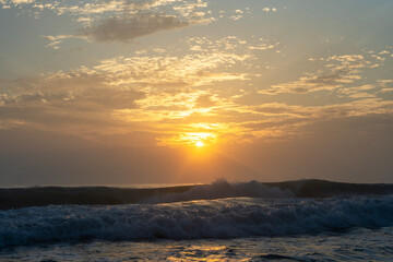 Beautiful sunrise over the ocean with dramatic wave. 