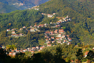Fototapeta premium Traditional buildings, mountain houses. The nature and architecture of Liguria. Blue skies, clouds, and a backdrop for design.