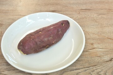 grilled Japanese purple yam with peel arranging on plate 