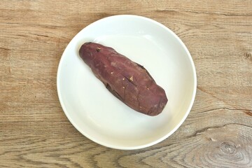 grilled Japanese purple yam with peel arranging on plate 