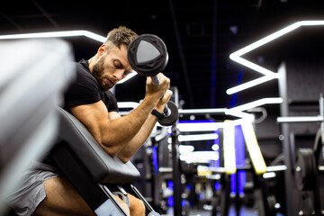 Man performing bicep curls in modern gym with stylish lighting