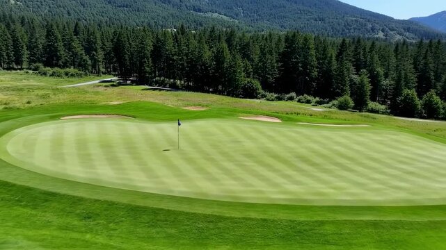 Aerial View of a Pristine Golf Course Green with Flagstick, Sand Traps, and a Forested Mountain Backdrop