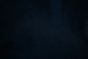Macro view of dark blue woven technical fabric with a fine zigzag pattern and smooth texture. Dim lighting. © Jolanta