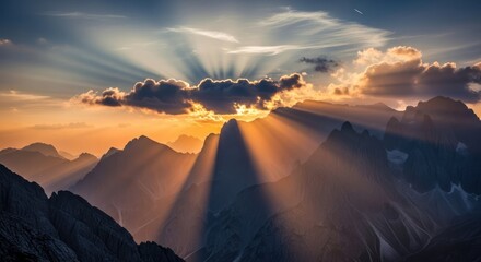 Dramatic mountain range landscape with sun rays shining through clouds