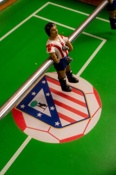 Cepeda, Salamanca - November 08, 2025: Futbolin, table football. Plastic soccer player with a ball on a toy field, from the Spanish team Atletico Madrid