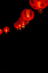 Group of red paper Chinese lanterns with blessing word mean happy, healthy and wealth. Background for Chinese New Year greeting theme. Vertical image and Selective focus.