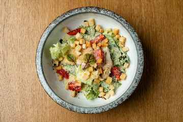 Bright greens and vibrant reds fill a stylish bowl. Croutons and delicate herbs add texture and flavor, creating a fresh and inviting dish perfect for a light meal