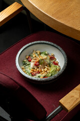 A colorful salad sits in a stylish bowl, featuring fresh greens, crunchy croutons, and delightful toppings