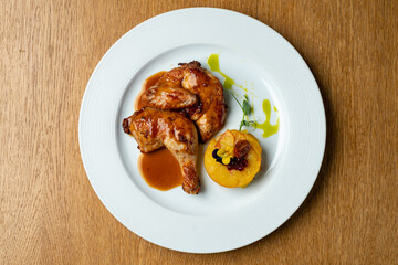 Juicy roasted chicken thighs are plated with a smooth, creamy polenta and drizzled with a flavorful sauce. Fresh herbs add a touch of elegance to this delicious meal