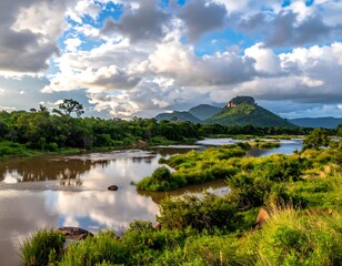 Obraz premium Wide river flowing through lush, green landscape under a dramatic, cloudy sky