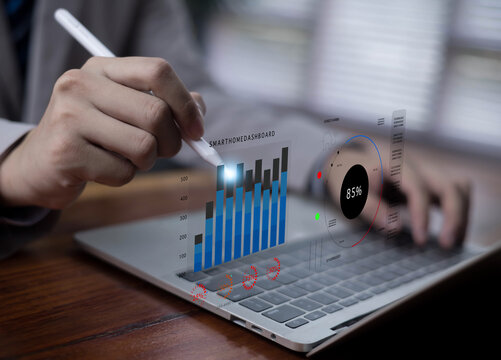 A person using a laptop with a digital smart home dashboard, featuring interactive charts, data analytics, energy monitoring, and IoT technology for modern automation and intelligent system