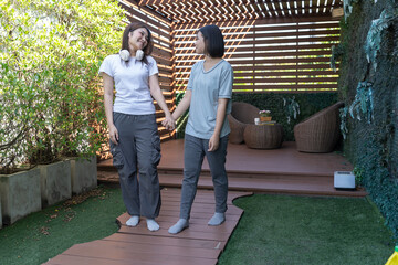 Friendship Stroll: Two friends share a joyful moment, their hands clasped in a gesture of unity, as they leisurely walk in a beautiful, natural setting.