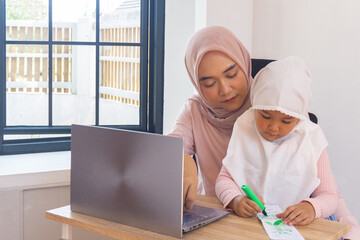 Happy mom working remotely and daughter drawing. Modern family life