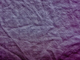 close-up of wrinkled purple fabric texture with subtle gradient from light to dark tones and woven pattern on pale blue background