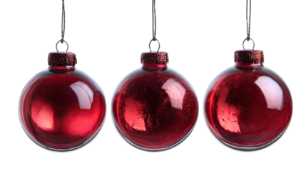 Three ruby red glass Christmas ornaments hanging with crystal clarity on transparent background
