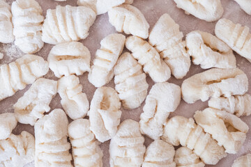 Fresh gnocchi ready for cooking. The photos capture the authentic atmosphere of Sunday cooking, with natural light and details of the handiwork typical of Italian tradition.