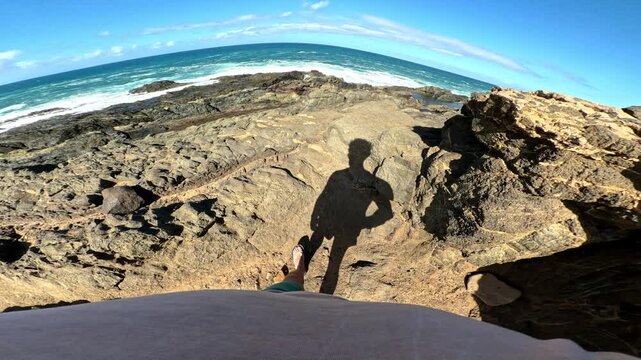 Point of view walking and clambering across rocky crevices and pools of ocean water in Fuerteventura, Spain 