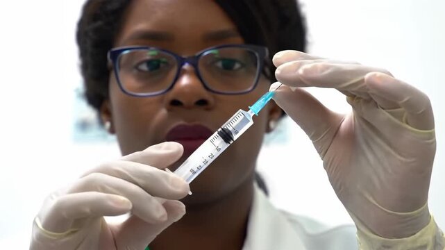 Focused healthcare professional carefully preparing a syringe for a medical procedure, demonstrating precision and expertise in medication or vaccine administration