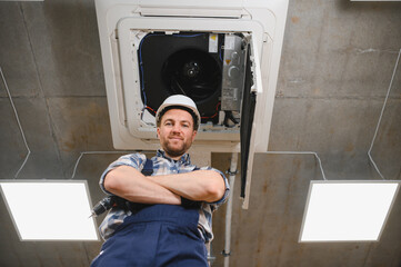Hvac technician installing air conditioning unit in building