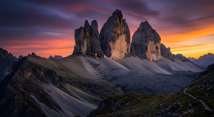 Fototapeta premium Majestic mountain range silhouetted against a vibrant sunset with a scenic trail