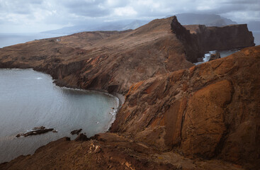 Dramatic volcanic cliffs and serene ocean view at Ponta de S&atilde;o Louren&ccedil;o, Madeira Island, Portugal &ndash; panoramic coastal landscape with sailboats, hiking trails, and wild natural beauty.