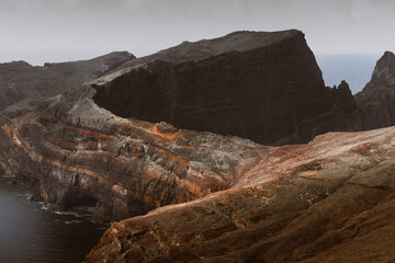 Dramatic volcanic cliffs and serene ocean view at Ponta de S&atilde;o Louren&ccedil;o, Madeira Island, Portugal &ndash; panoramic coastal landscape with sailboats, hiking trails, and wild natural beauty.