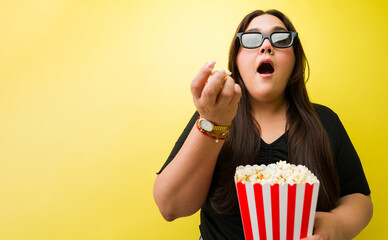 Obraz premium Woman wearing 3d glasses eating popcorn