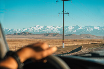 Road trip driving across grassland and mountain range in countryside