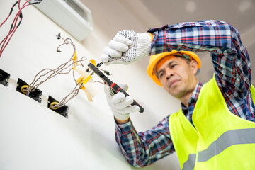 Electrician performing wiring repairs in a modern office professional action indoor environment close-up view for safety awareness