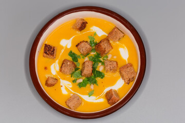 Pumpkin-lentil soup-puree with croutons in bowl, top view