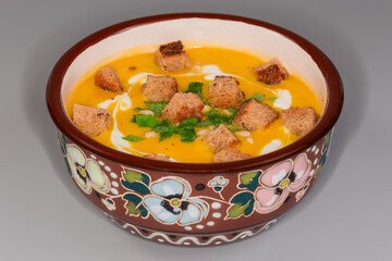 Pumpkin-lentil soup-puree with croutons in bowl, front view