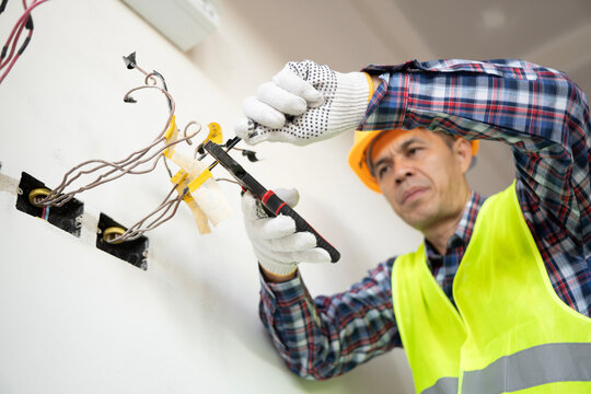 Electrical repair action by technician in residential space focus on wiring and tools indoor setting professional viewpoint - Powered by Adobe