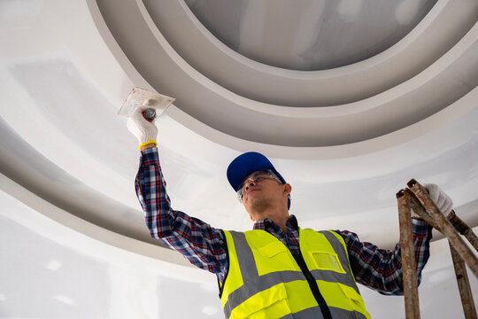 Interior painting action by a worker construction site image urban environment low angle building maintenance concept