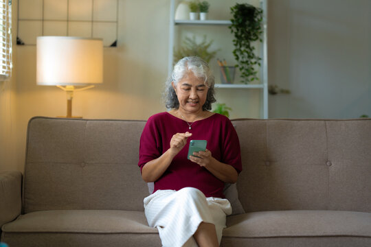 relaxed senior woman stays connected with social media on her smartphone at home