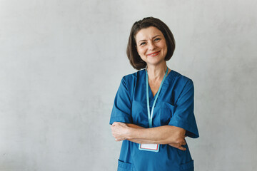 Successful confident Caucasian female massage therapist or kinesiotherapist posing against grey...