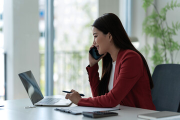 Professional office woman working with computer and documents while maintaining career focus at desk