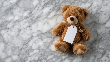 Cute teddy bear with blank tag on marble surface