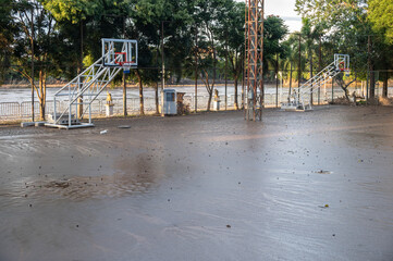 Fototapeta premium Basketball court having damaged by mud flooded after Kok river rising and flooding Chiang Rai province, Thailand.