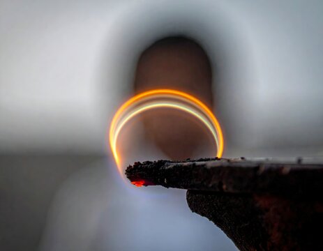 Captivating long exposure light painting reveals a fiery arc over a dark texture