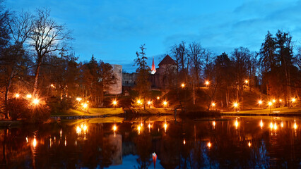 Obraz premium colorful and bright autumn landscape from the city park in dark autumn, illuminated pond with charming reflections in the water, Cesis, Latvia