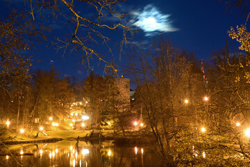 Obraz premium colorful and bright autumn landscape from the city park in dark autumn, illuminated pond with charming reflections in the water, Cesis, Latvia