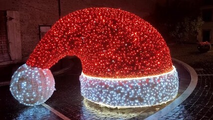 A red heart shaped strawberry topped with a cute Santa hat, creating a festive Christmas themed food decoration on a clean white background.