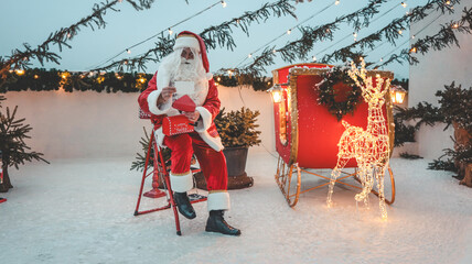 Santa Claus reading letters with a sleigh and reindeer decorations