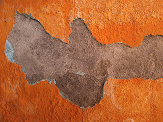 Peeling Orange Paint Revealing Dark Textured Wall Surface