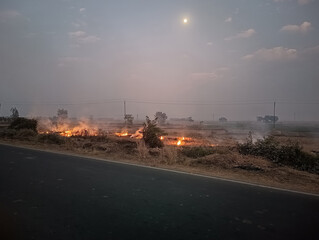 Agricultural Burning in a Hazy Rural Landscape at Dusk