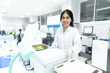 Asian woman scientist and centrifuge for pre analysis blood test  in laboratory department.Laboratory technician using centrifuge device automation machine for testing and diagnostic specimens sample.